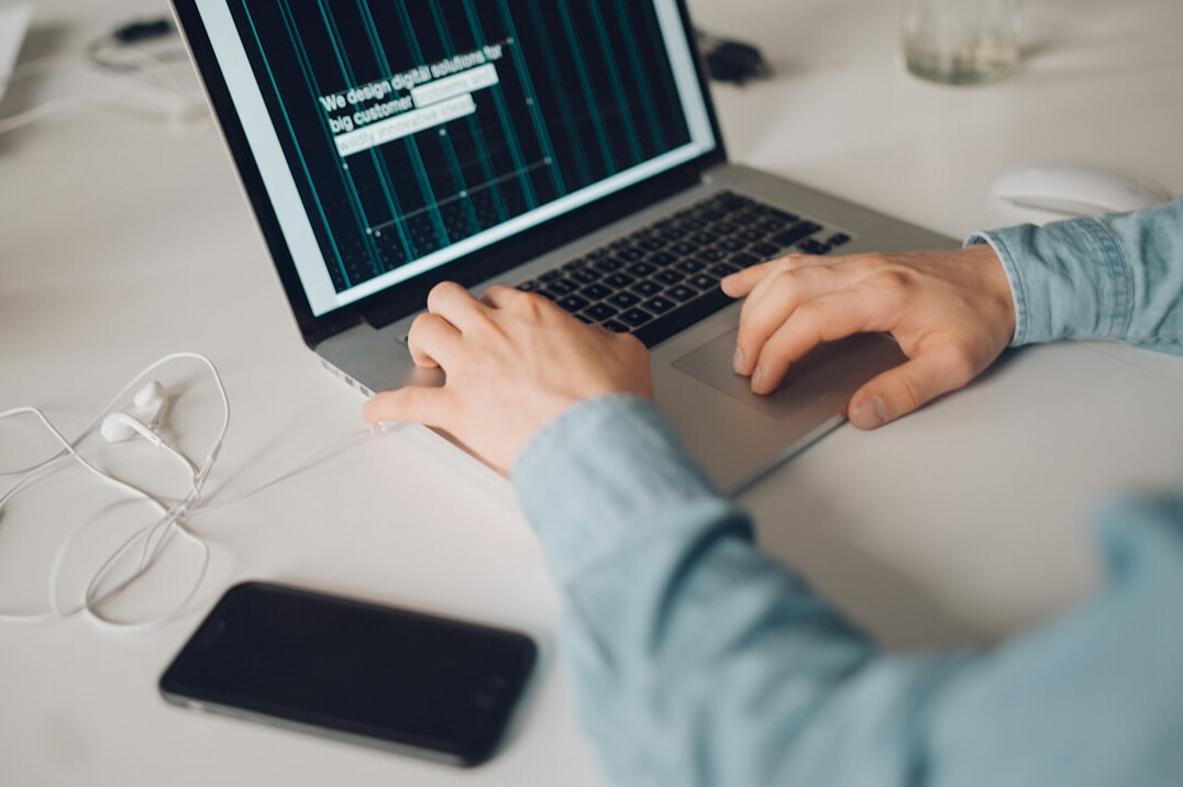 person coding on laptop