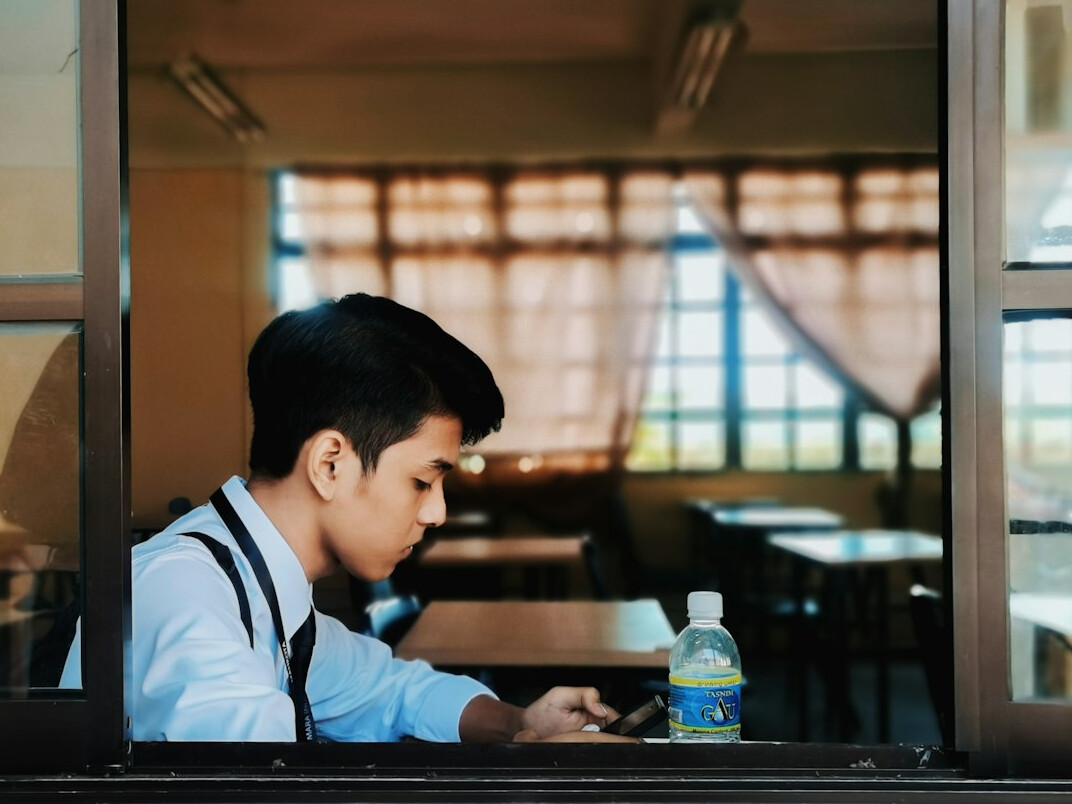 Young Malaysian student learning to code on a laptop