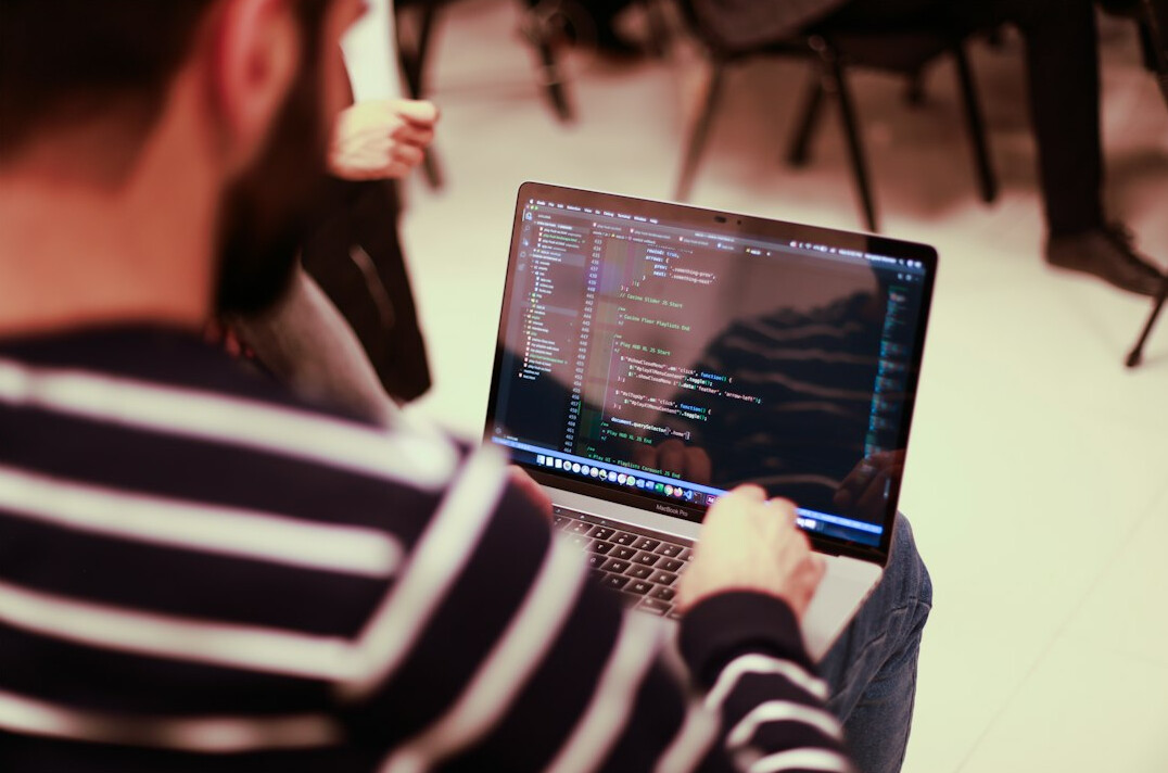 person coding on laptop